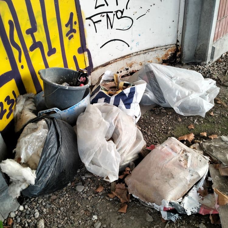 Gravats de chantier, pneu, déchets divers sous un pont au bord de la route 