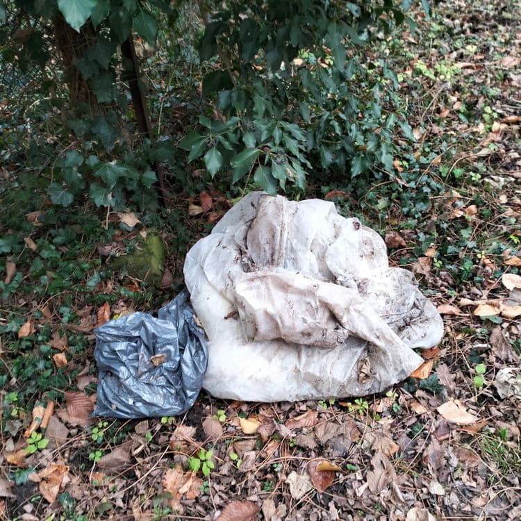 Sacs poubelles abandonnés à côté d'un ruisseau 