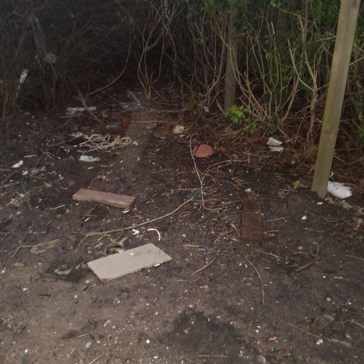 Bache bleu,morceaux de bois, barrière de chantier et déchets plastiques 