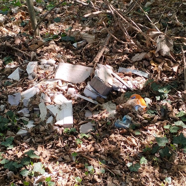 Gravats et pièces plastiques abandonnés au bord d'une piste cyclable 