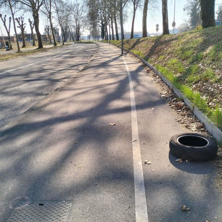 Un pneu usagé abandonné sur une piste cyclable 