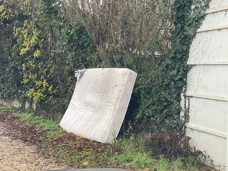 Voici une analyse des déchets présents sur l'image :

Un matelas est visible, estimé à environ 25 kg, il y en a une unité.
