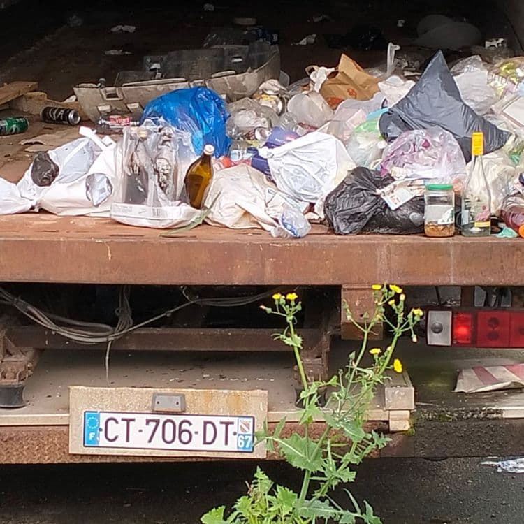 Sur parking routier, deux vieilles semi remorques inutilisées servent de déchetterie. Déchets divers, sacs poubelles 
