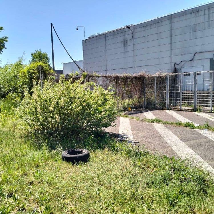 Une roue complète abandonnée au bord d'une route à l'arrière d'un hyper marché 