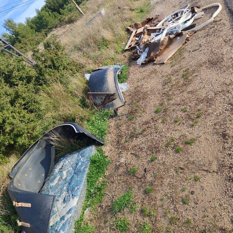 Voici une estimation des déchets présents sur le site :

*   **Débris automobiles:** On observe des éléments de carrosserie, potentiellement des pare-chocs ou des ailes. On estime le poids total de ces pièces à environ 15 kilogrammes et la quantité à 3 pièces.

*   **Matelas:** Un morceau de matelas est visible. Son poids est estimé à environ 8 kilogrammes et on estime qu'il y a une seule pièce.

*   **Déchets divers de construction/démolition:** Un amas de matériaux variés comprenant du bois, du plastique, des isolants et potentiellement des éléments métalliques est présent. Le poids de ces déchets est estimé à environ 25 kilogrammes. On estime qu'il y a un amas de plusieurs pièces.