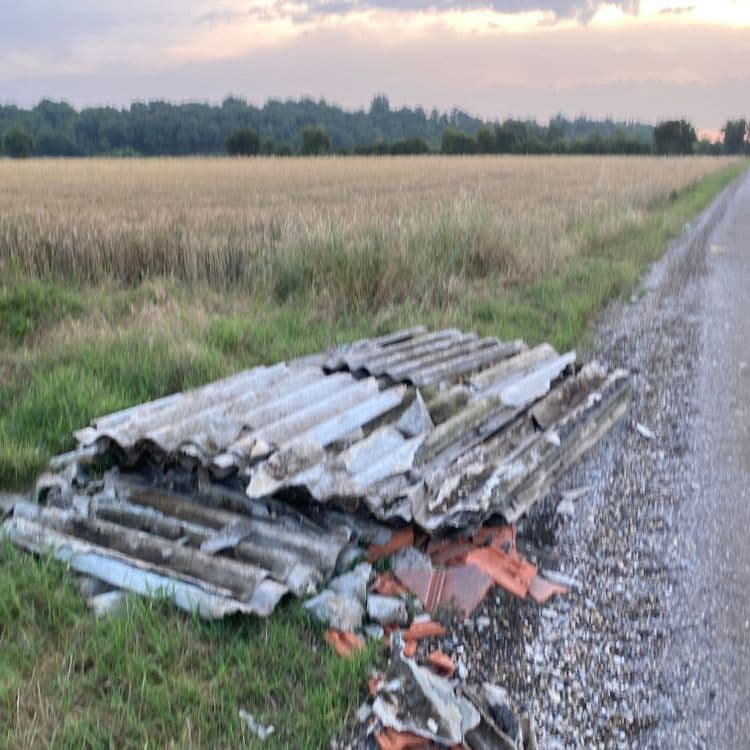 Voici l'analyse des déchets présents sur l'image :

On observe un dépôt sauvage composé principalement de plaques de fibrociment ondulées. La quantité estimée est d'environ 15 plaques, représentant un poids total d'environ 150 kilogrammes, en raison de la présence d'amiante ces déchets demande des précautions particulières.

On constate également la présence de quelques tuiles en terre cuite cassées, environ 5 kilogrammes, issues probablement d'une toiture. 
