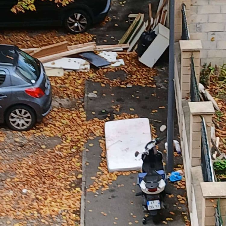 Un matelas déposé sur le trottoir et un meuble. 