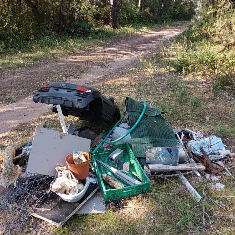 Voici une estimation des déchets présents sur l'image :

*   **Plastiques:** On observe des éléments de carrosserie automobile (pare-chocs) et des débris divers. Poids estimé : 5 kg, quantité : plusieurs fragments.
*   **Mobilier:** Présence de divers éléments de mobilier (planche de bois, porte). Poids estimé : 10 kg, quantité : divers fragments.
*   **Déchets verts:** Une natte et un tuyau d'arrosage. Poids estimé : 3 kg, quantité : 1.
*   **Divers:** Un cageot, un pot de fleur, un cadre, divers éléments métalliques (grillage, ferrailles). Poids estimé : 7 kg, quantité : plusieurs éléments.
*   **Textiles:** Présence de cordes et de tissus. Poids estimé : 2 kg, quantité : 1.

Le poids total estimé des déchets est d'environ 27 kg. Les quantités sont variables selon le type de déchet.
