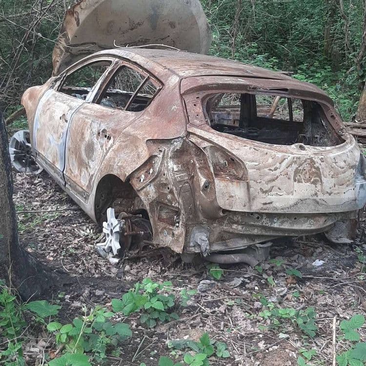 Voiture brûlée et abandonnée dans la forêt