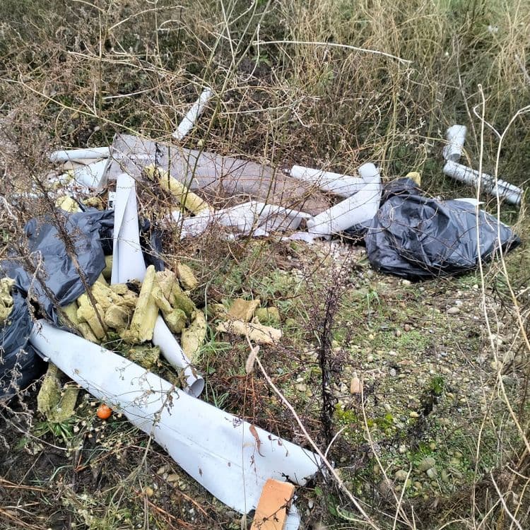 Déchets divers et du bâtiment abandonnés au bord d'un parking en zone commerciale 