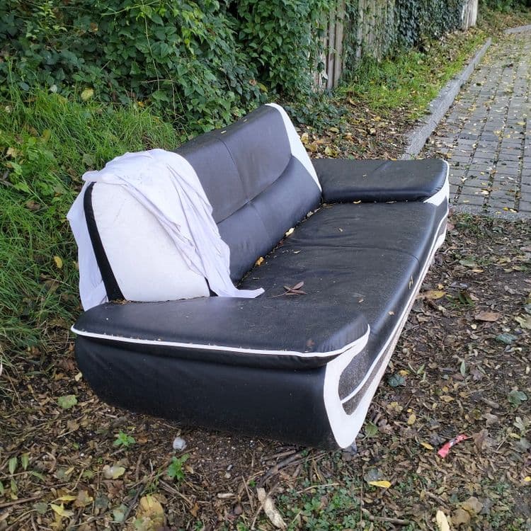 Un canapé abandonné sur un parking public 