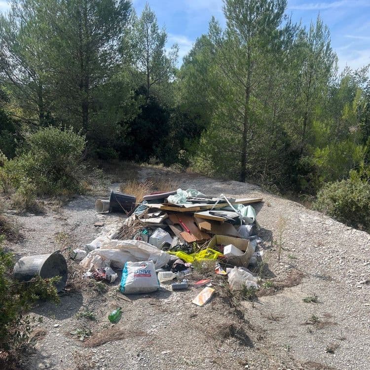 Voici l'analyse des déchets présents sur l'image :

On observe un dépôt sauvage composé de plusieurs types de déchets.

*   **Déchets de construction/démolition :** Il y a des planches de bois aggloméré, des restes de placo plâtre, et divers éléments de construction. Le poids estimé pour cette catégorie est d'environ 50 kg. La quantité est d'environ 10 pièces.
*   **Encombrants :** Un ancien écran de télévision est visible, ainsi qu'un matelas et des éléments plastiques divers. Le poids estimé pour les encombrants est d'environ 25 kg. La quantité est d'environ 3 pièces.
*   **Sacs et déchets plastiques :** Divers sacs en plastique, films plastiques, et autres emballages sont présents. Le poids estimé pour les plastiques est d'environ 10 kg. La quantité est d'environ 10 pièces.
*   **Déchets divers :** On trouve également un sac de granulats (type "DRIVE"), un seau métallique, des cartons, et divers petits objets non identifiés. Le poids estimé pour cette catégorie est d'environ 30 kg. La quantité est d'environ 10 pièces.

Le poids total estimé de ce dépôt sauvage est donc d'environ 115 kg.
