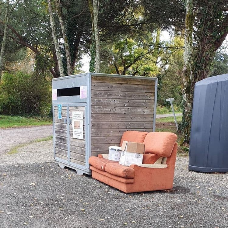 Canapé et pot de peinture devant l’aire des poubelles