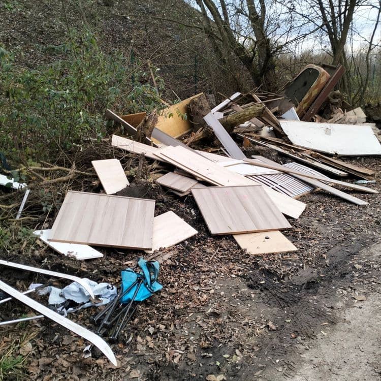 Pneus usagés, déchets divers abandonnés sur un chemin d'accès à un chantier 