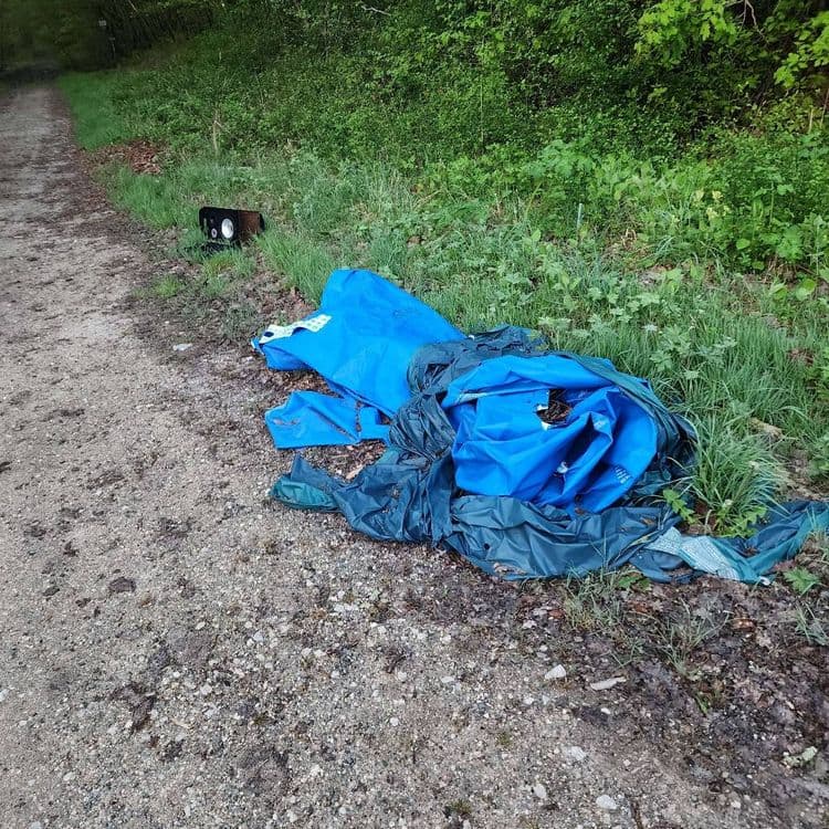 Les déchets abandonnés sur cette image comprennent une tente en tissu de couleur bleue et verte, ainsi qu'un haut-parleur de type enceinte.

Estimation du poids :
*   Tente : environ 3 kg
*   Enceinte : environ 5 kg

Quantité :
*   Une tente
*   Une enceinte