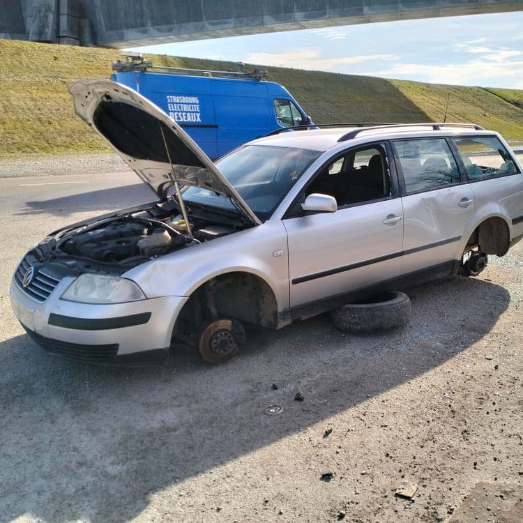 Voiture abandonnée sur un terrain vague au bord de la route 
