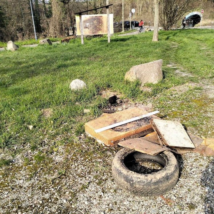 Sacs poubelles et déchets divers abandonnés sur un parking public 