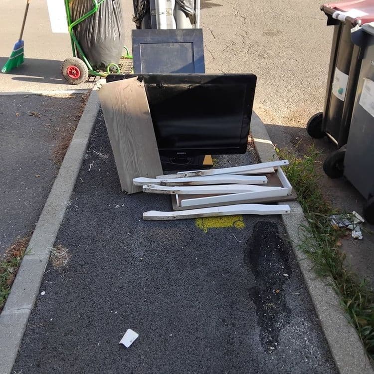 Voici une estimation des déchets présents sur la photo :

*   **Téléviseur :** Un téléviseur de type écran plat, estimé à environ 10 kg. Il y a une unité.

*   **Meuble en bois :** Divers éléments de meuble en bois, comprenant une planche et plusieurs pieds ou supports peints en blanc. Le poids total est estimé à environ 5 kg. On dénombre une planche et environ 6 pieds/supports.

*   **Divers :** Présence d'un sac poubelle non identifiable précisément et d'un petit papier. On ne peut pas estimer le poids ni la quantité.
