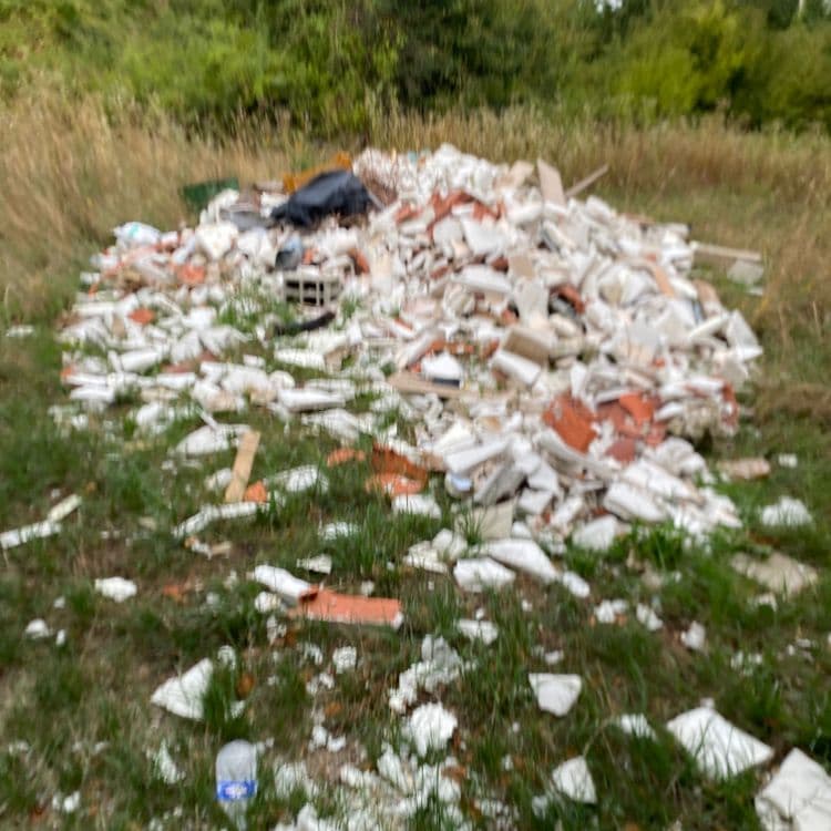 Voici une estimation des déchets présents sur la photo :

*   **Déchets de construction et de démolition (gravats)** : Il s'agit majoritairement de fragments de briques, de tuiles, de plâtre et de béton. La quantité est importante, estimée à environ 250 kg.
*   **Déchets plastiques divers** : On observe la présence de sacs en plastique (notamment un sac noir), ainsi que d'une bouteille en plastique. Le poids total est estimé à 5 kg, réparti sur environ 10 éléments.
*   **Déchets de bois** : Quelques morceaux de bois sont visibles, avec un poids estimé à 3 kg pour environ 5 éléments.
*   **Autres déchets** : On distingue un bloc de béton. Le poids est estimé à 10 kg.