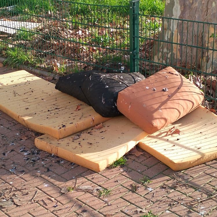 Coussins et blocs de mousse abandonnés sur un parking privé 