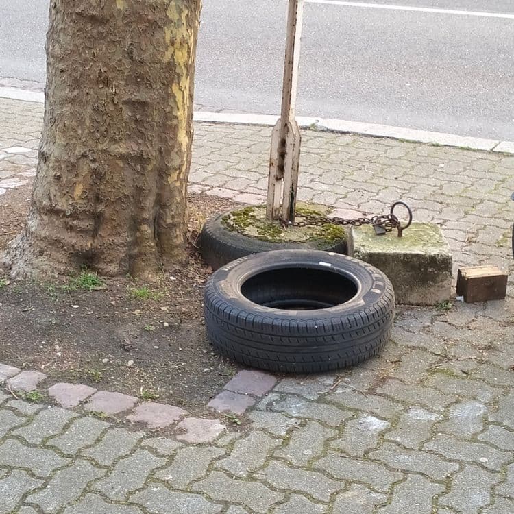 Pneu usagé abandonné sur un trottoir 