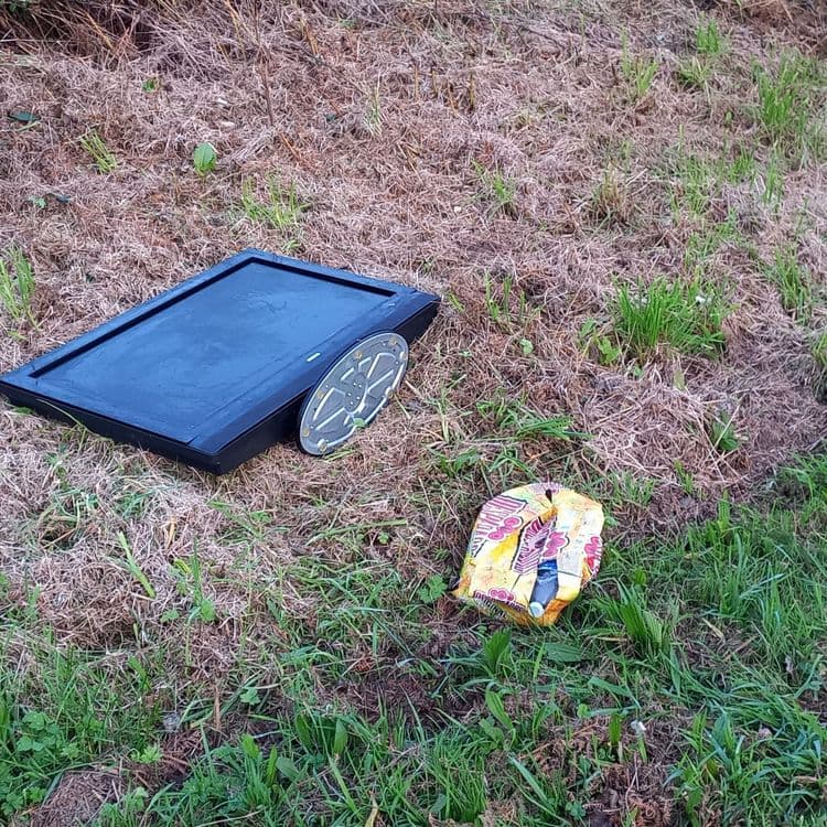 1 TV et 1 carton de bières (contenant 1 bouteille plastique) abandonnés en bordure d'une route de campagne. 