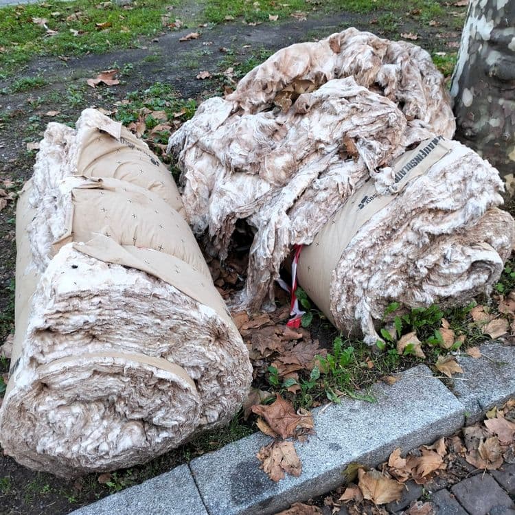 Rouleaux d'isolant abandonnés sur un parking public 