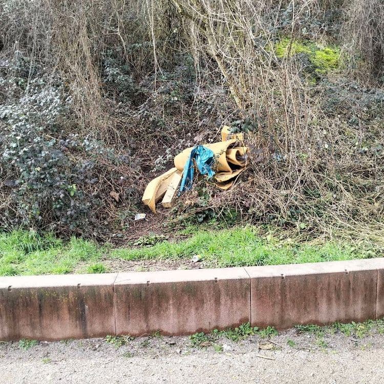 Restes de morceaux de mousse abandonnés sur un talus routier à côté d'un parc de jeux 