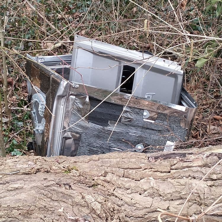 Palettes bois et une carcasse de lave vaisselle abandonnées en pleine forêt 
