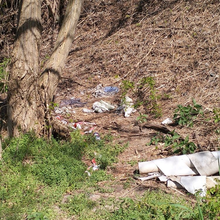 Déchets divers abandonnés au bord d'une piste cyclable 