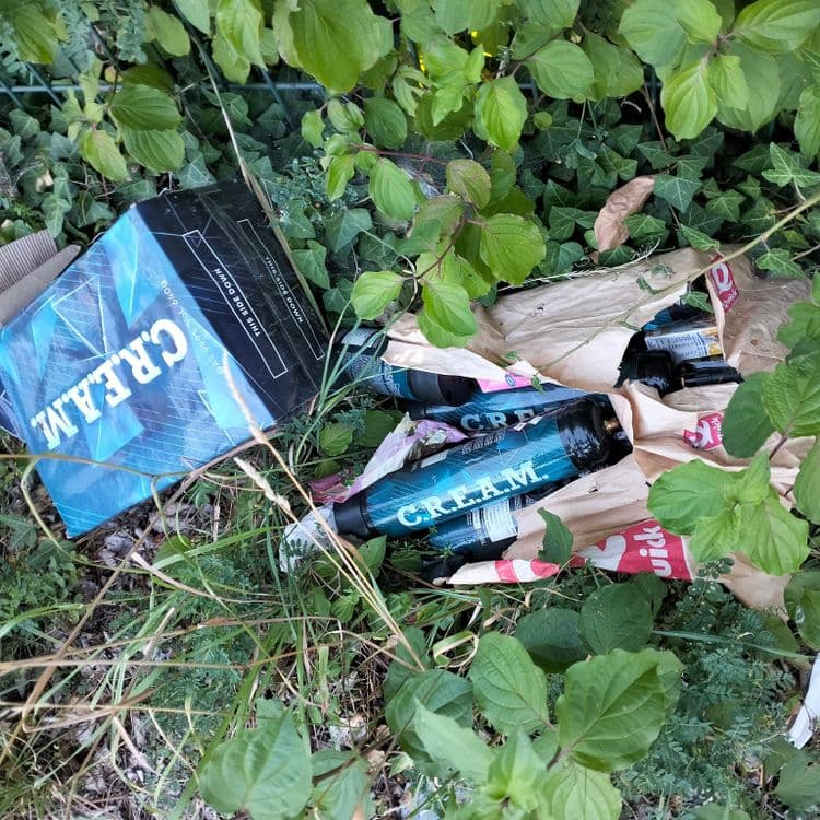 Bouteilles de protoxyde d'azote abandonnées sur un chemin en bordure d'autoroute 