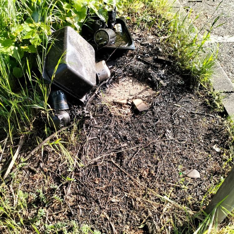 A proximité d'un garage (Norauto) et sur un parking de zone commerciale, traces de vidanges sauvages, bidons d'huile usagée, pneus usagés, bacs à huile et filtres usagés, déchets divers.