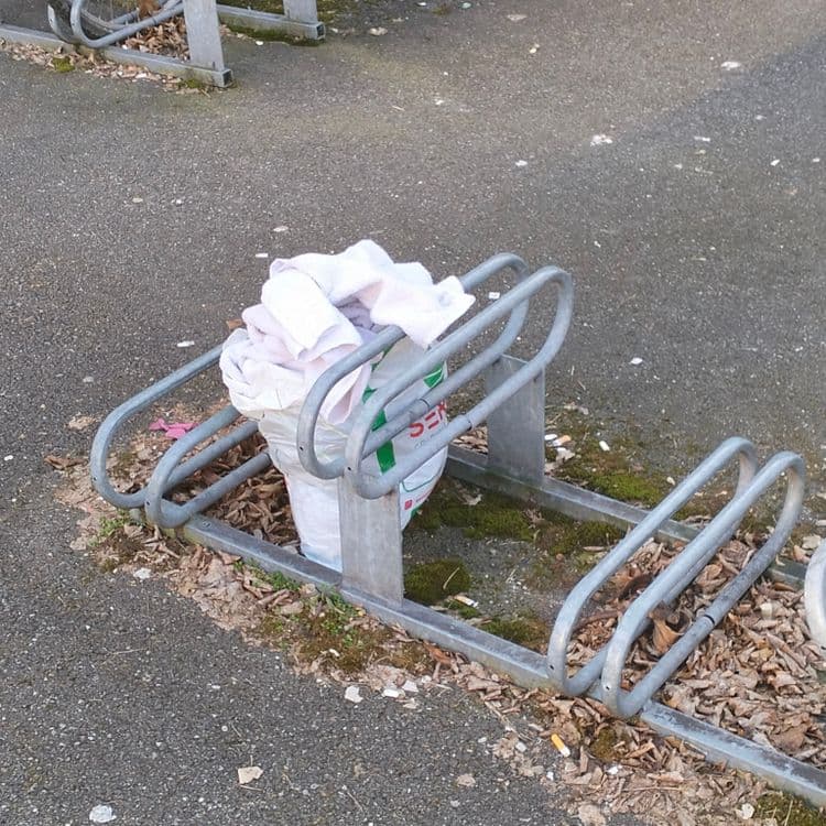 Sac rempli de linge abandonné dans un rack pour vélo 