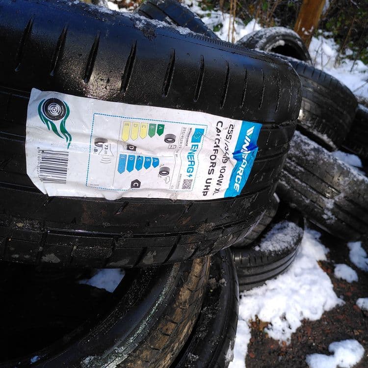 Une décharge sauvage de pneus de voiture usagés et neufs sur le bord de la route forestière. Il s'agit d'environ 40-50 pneus.