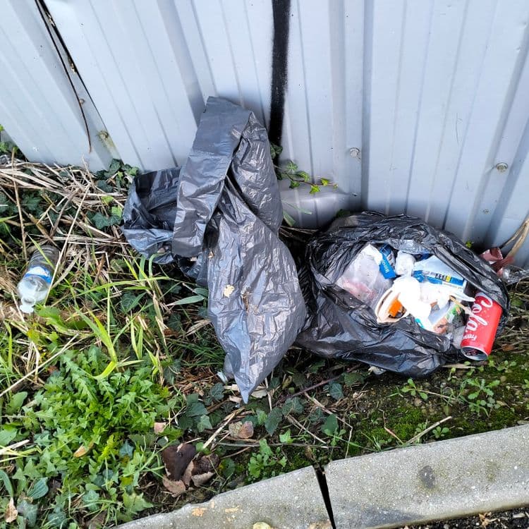 Deux pneus usagés et un sac poubelle abandonné en zone industrielle 