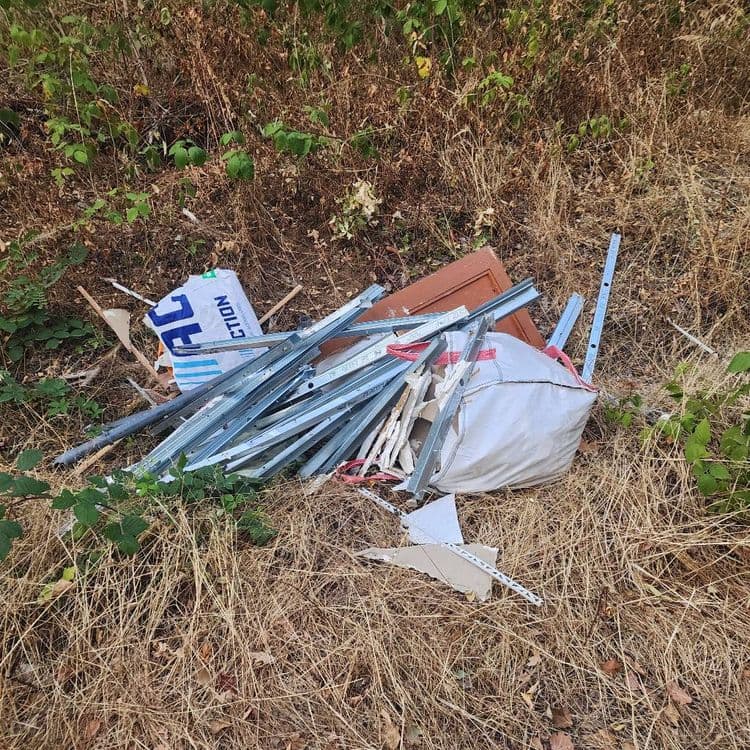 Voici la liste des déchets abandonnés sur le site :

*   **Profilés métalliques (rails et montants de placo):** Environ 25 à 30 pièces, pour un poids total estimé à 35 kilogrammes.
*   **Grand sac de gravats (type big bag):** 1 sac, contenant probablement des déchets de chantier divers, pour un poids estimé à 70 kilogrammes.
*   **Panneau ou fragment de porte en bois:** 1 pièce, pour un poids estimé à 15 kilogrammes.
*   **Emballage carton/papier (sac de ciment ou similaire):** 1 pièce, pour un poids estimé à 1 kilogramme.
*   **Chutes de placo ou d'isolant:** Plusieurs fragments, pour un poids total estimé à 3 kilogrammes.
*   **Tuyaux ou conduits en plastique:** Quelques pièces, pour un poids total estimé à 2 kilogrammes.
*   **Sangles ou liens en plastique/textile:** Plusieurs, pour un poids total estimé à moins de 1 kilogramme.