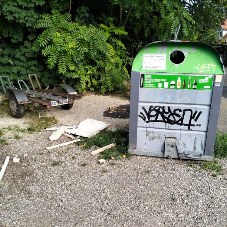 Pièces plastiques à côté d'un container à verre 
