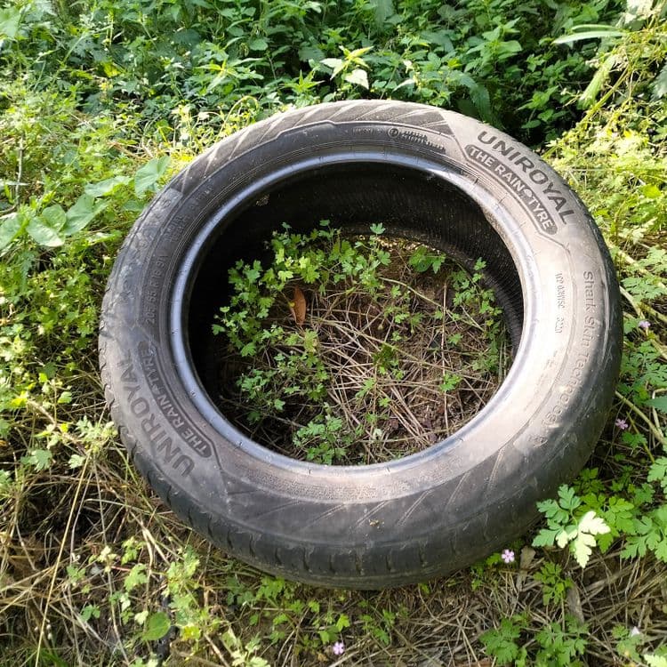 Pneu usagé, bidon d'huile usagée et sacs poubelles 