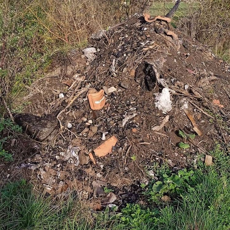 Tas de déchets calcinés sur une zone classée zone humide.