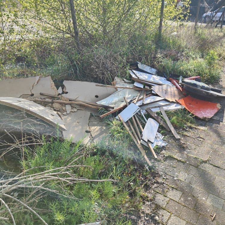 Déchets constatés :

* **Bois et contreplaqué :** Plusieurs morceaux de bois, de contreplaqué et de lambris cassés ou en mauvais état, estimés à environ 25 kg, soit une quantité d’environ 1 m³.

* **Béton :** Plusieurs fragments de béton, apparemment provenant d’une dalle ou d’un élément de construction similaire, pour un poids estimé à 40 kg et un volume d’environ 0,1 m³.

* **Plastique :** Un élément plastique noir, de forme circulaire et de taille importante (potentiellement une couverture ou une partie d’un équipement), son poids est estimé à 5 kg. De plus, des morceaux de plastique plus petits sont dispersés parmi les autres déchets, pour un poids estimé à 2 kg.

* **Métal :** Des morceaux de métal rouillés ou oxydés, difficilement identifiables avec précision, pour un poids total estimé à 3 kg.

**Total estimé :** 75 kg de déchets environ.  Ce total est une estimation et peut varier légèrement.  Une évaluation sur place serait nécessaire pour une plus grande précision.
