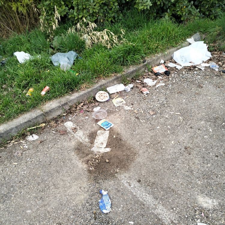 Déchets divers abandonnés sur un parking à côté d'un canal 