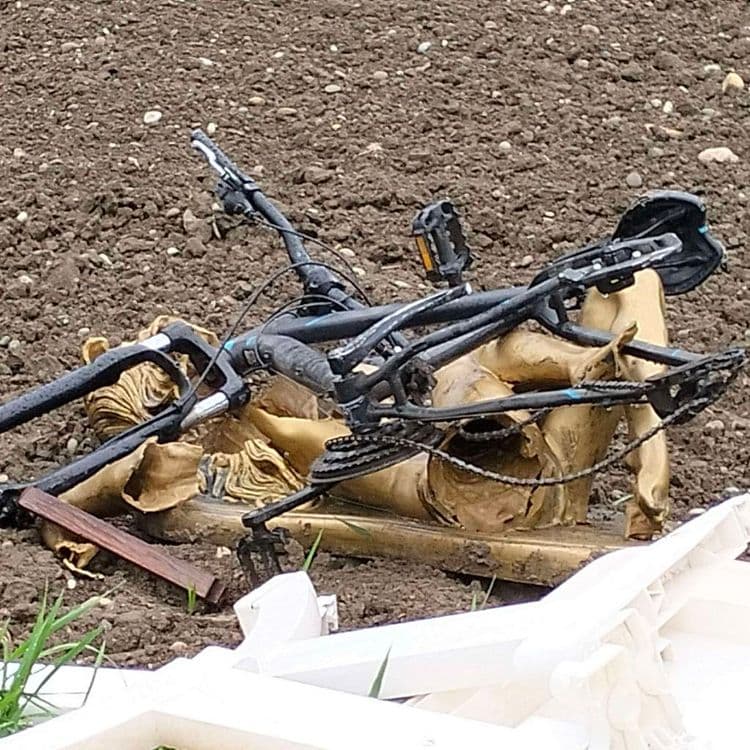 Vélo, table plastique, téléviseur et déchets divers abandonnés au bord d'un champ 