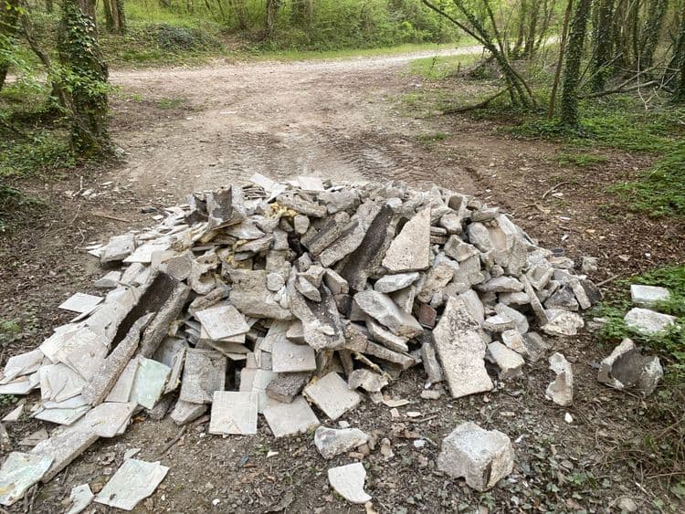 Voici une analyse des déchets présents sur l'image, destinée à la commune concernée.

Nous constatons la présence de plusieurs types de déchets de construction et de démolition. Une quantité importante de gravats, comprenant des morceaux de béton, des pierres et des fragments de tuiles ou carrelages, est visible. Les déchets semblent provenir de travaux de rénovation ou de démolition.

Estimation des quantités et poids :

*   **Gravats (béton, pierres) :** Environ 800 kg, comprenant des blocs de différentes tailles.
*   **Tuiles/Carrelages :** Environ 150 à 200 pièces, représentant un poids estimé à environ 50 kg.
* **Isolant (laine minérale)** Présence de laine minérale en faible quantité, estimée à environ 1kg.