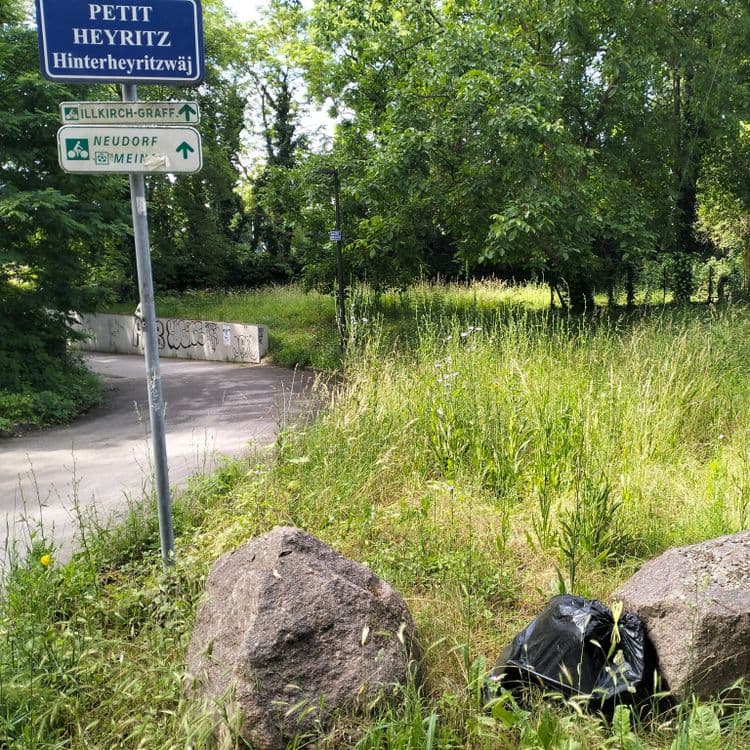 Sac poubelle au bord de la piste cyclable 