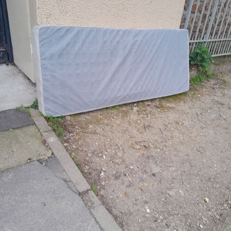 Matelas jeté sur le trotoire 