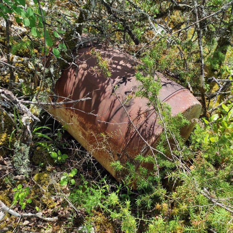 Les déchets abandonnés sur la photo comprennent une cuve métallique rouillée. Il n'y a qu'une seule cuve visible sur l'image.
