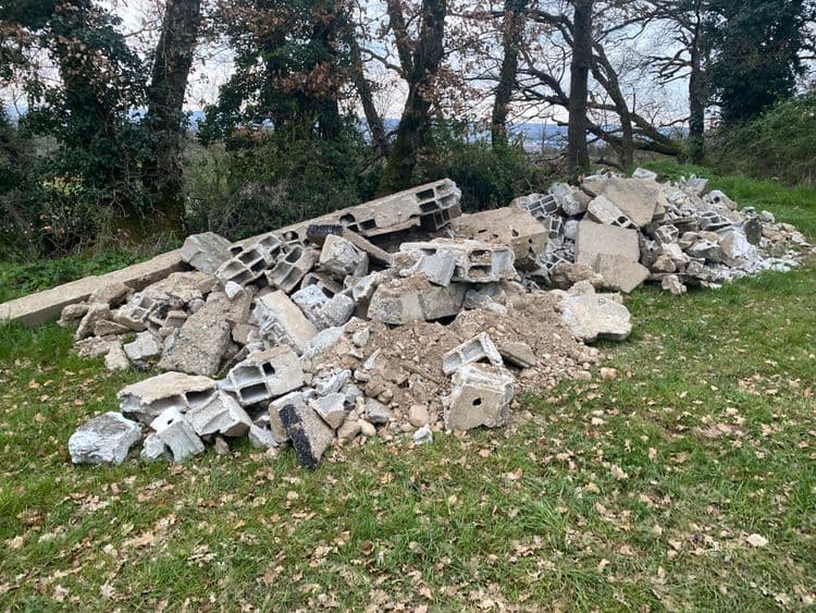 Voici l'analyse des déchets présents sur l'image :

On observe principalement des déchets de construction et de démolition, constitués de :

*   **Blocs de béton creux (parpaings)** : Environ 25 unités, représentant un poids total estimé à 250 kg (en considérant un poids moyen de 10 kg par bloc).
*   **Gravats de béton** : Divers morceaux et fragments de béton, estimés à environ 200 kg.
*   **Poutre en béton** : 1 unité, estimée à environ 80 kg.

Le poids total des déchets présents sur l'image est donc estimé à environ 530 kg.