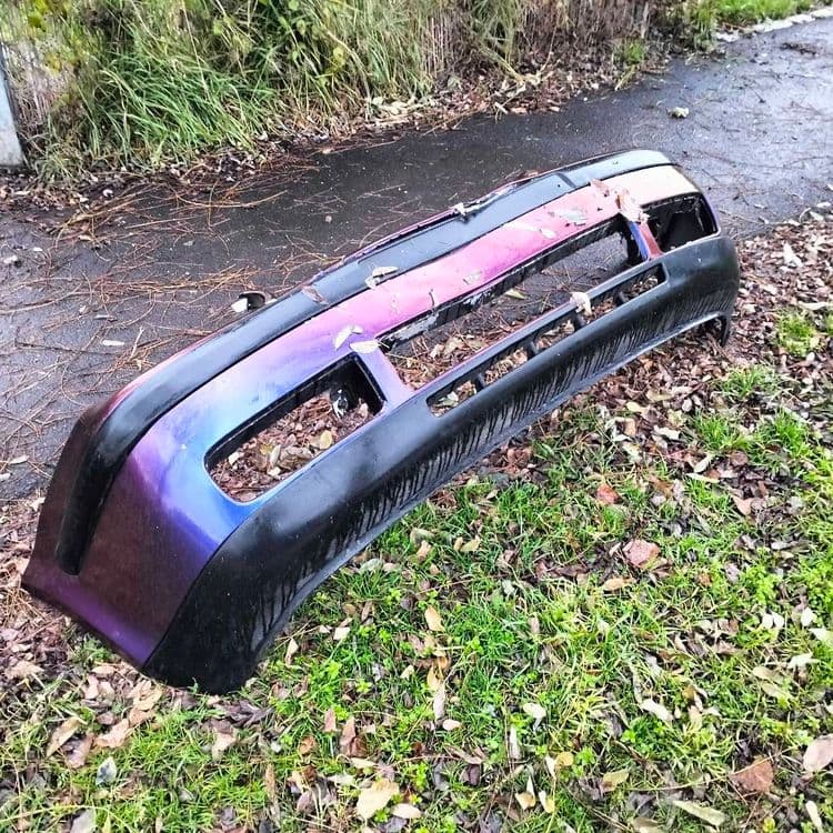 Pare choc de voiture abandonné sur un trottoir 
