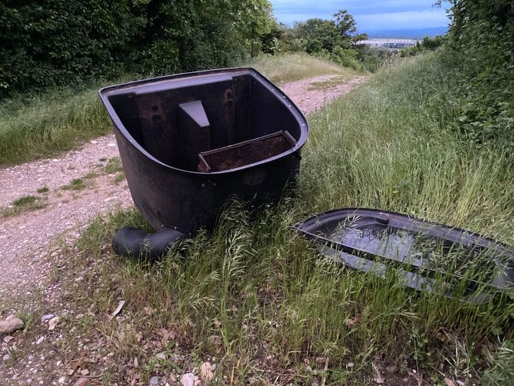 Voici l'analyse des déchets présents sur l'image :

*   Une cuve en plastique noir, probablement utilisée dans un contexte agricole ou industriel : 20kg.
*   Un couvercle en plastique noir associé à la cuve : 5kg.
*   Une grille métallique : 2kg
