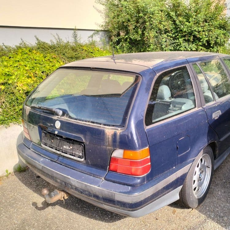 Voiture abandonnée sur parking de supermarché 
